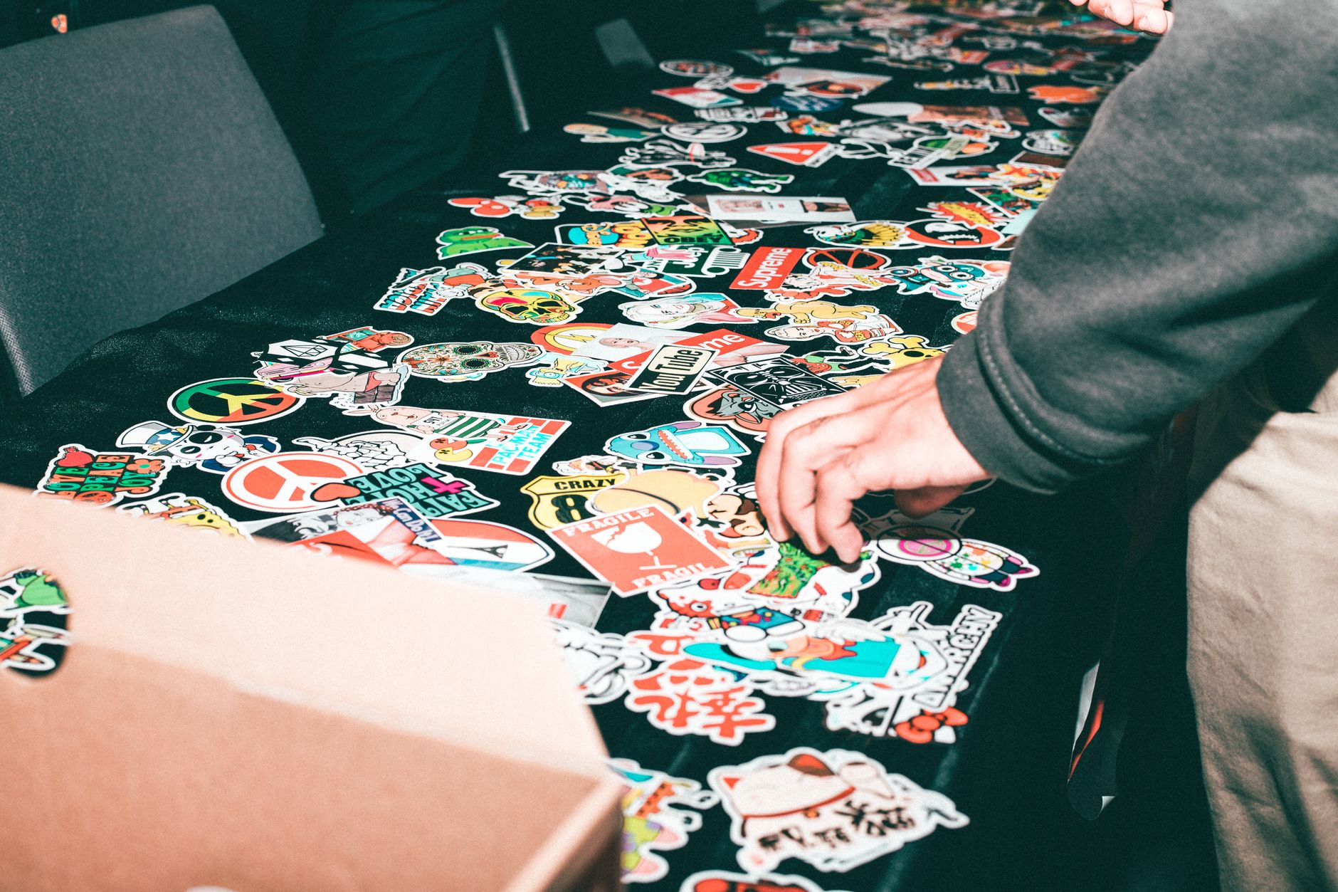 Charity merch table at a metal Christmas charity gig featuring patches and donation QR code